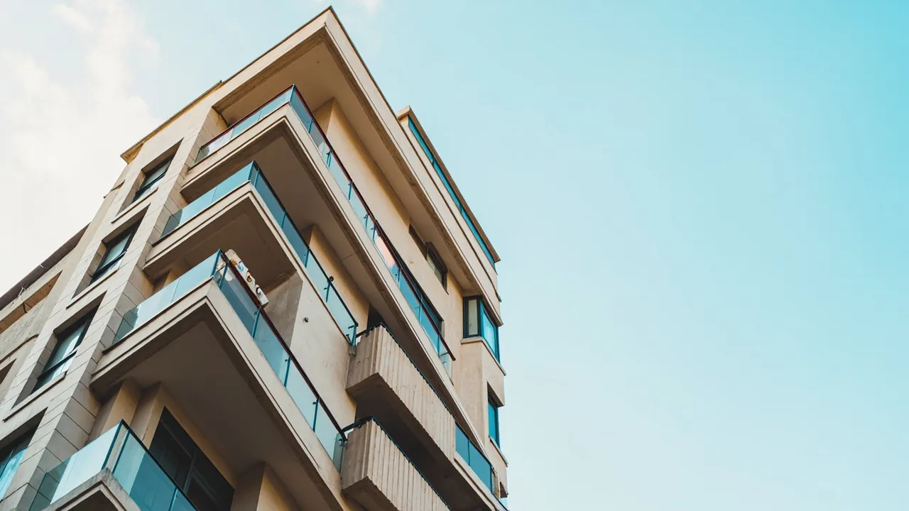 Zeitgenössische Apartmentfassade mit Balkonen vor klarem Himmel